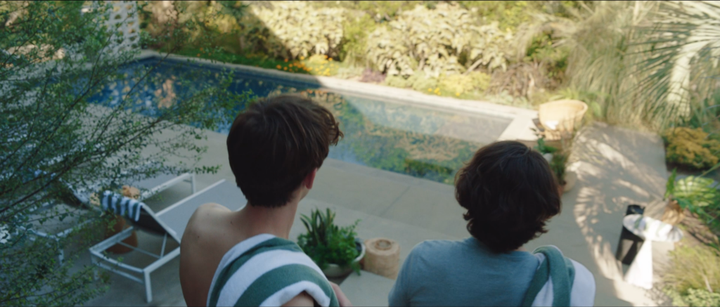 Two men look forward towards a pool.