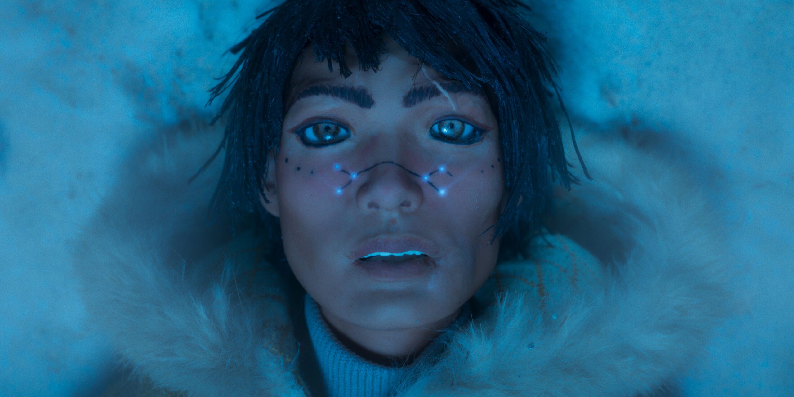 Person looks toward camera with lights on thier cheeks.