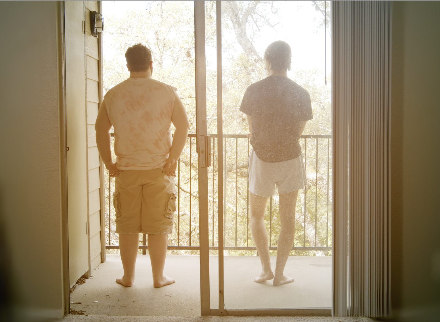 at-lucys-last-night2 Two people seen through screen door look out on patio.