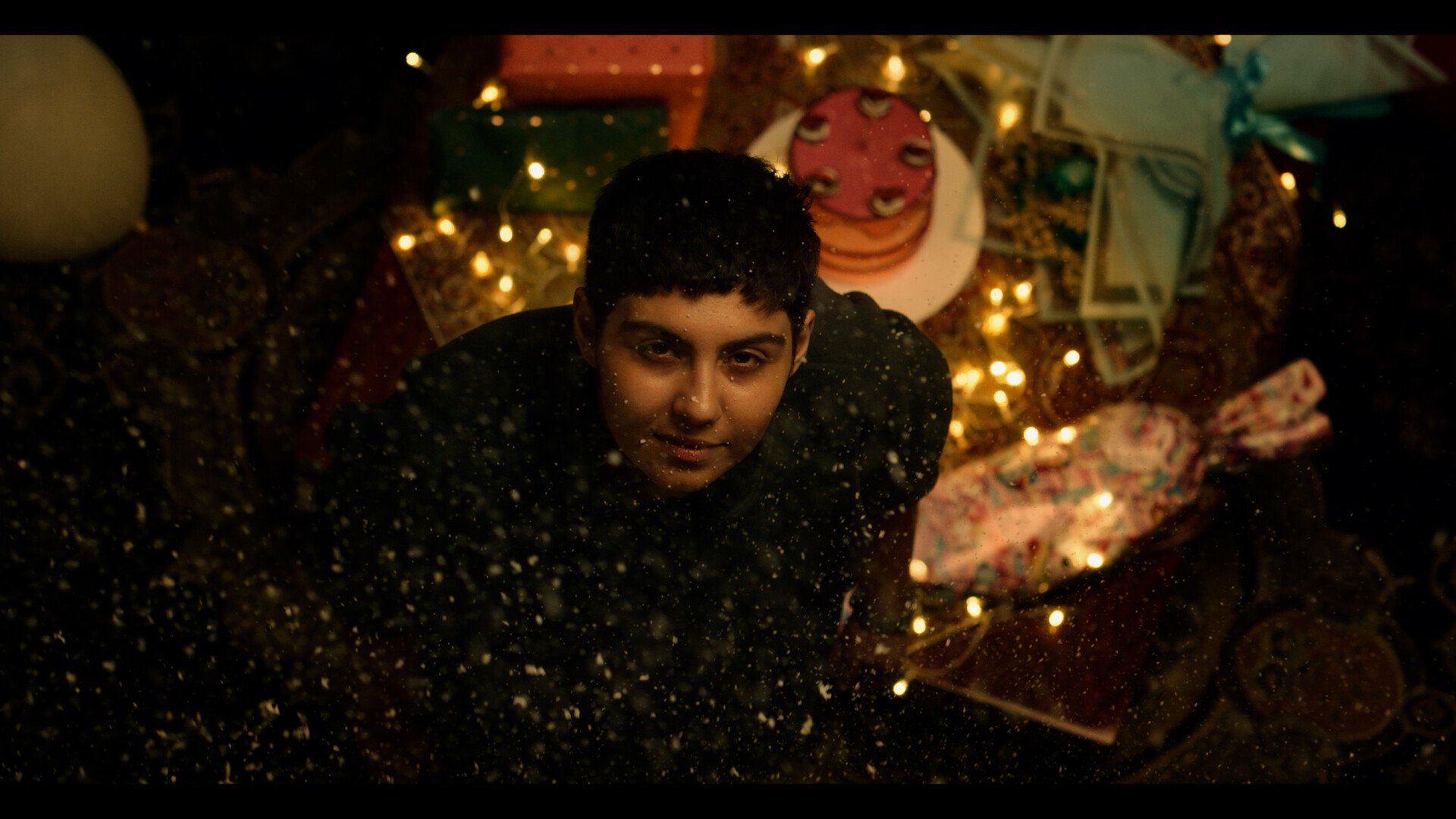 Person looks toward camera in low light setting.