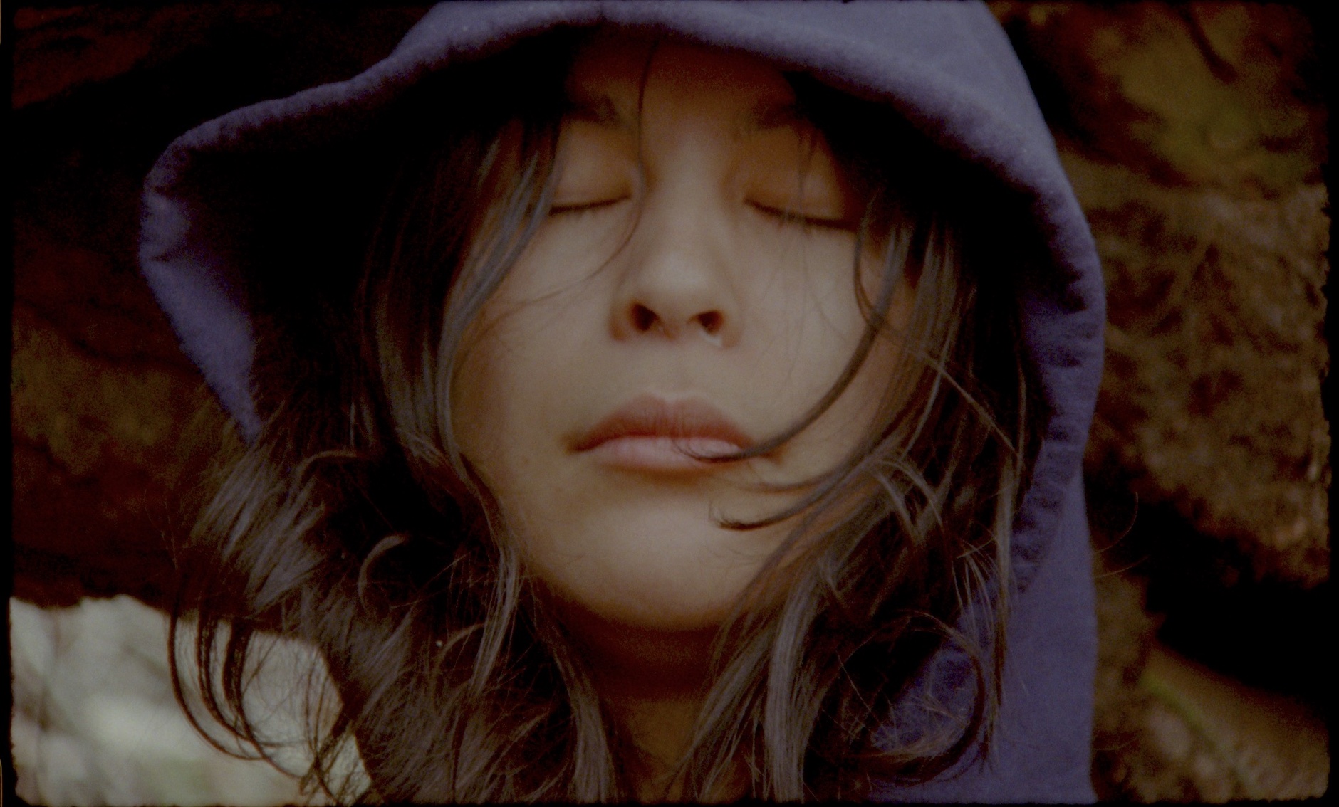 Person in purple hoodie closes eyes.