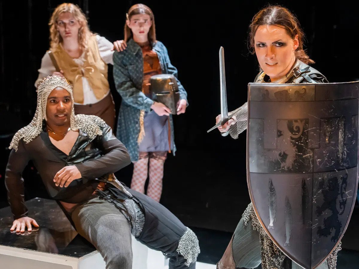 Performers on a stage dressed in medieval costumes.