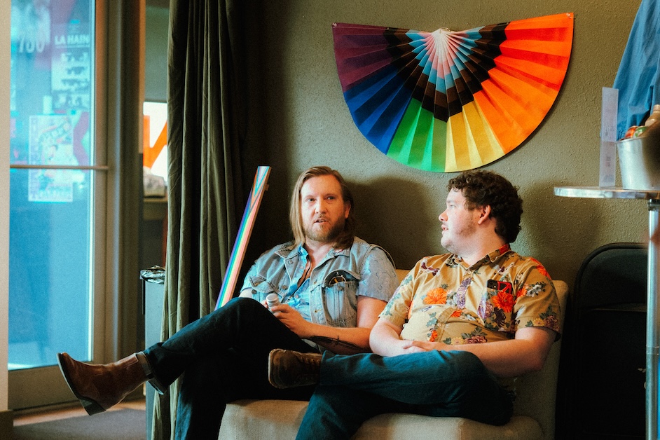 qwff_filmmaker_lounge People talking under fan with LGBTQ+ colors.