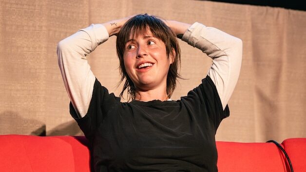 Person looking over during Q&A on stage for Queer West Film Festival.